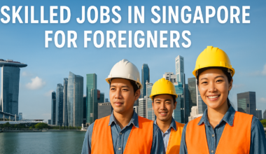 Three smiling construction professionals in safety gear stand in front of Singapore’s Marina Bay skyline. Large headline text reads “Skilled Jobs in Singapore for Foreigners.